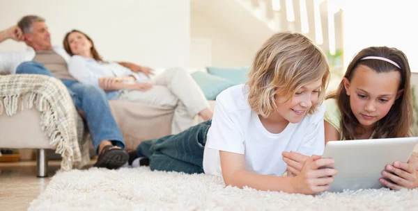 Siblings with tablet on the floor — Stock Photo, Image