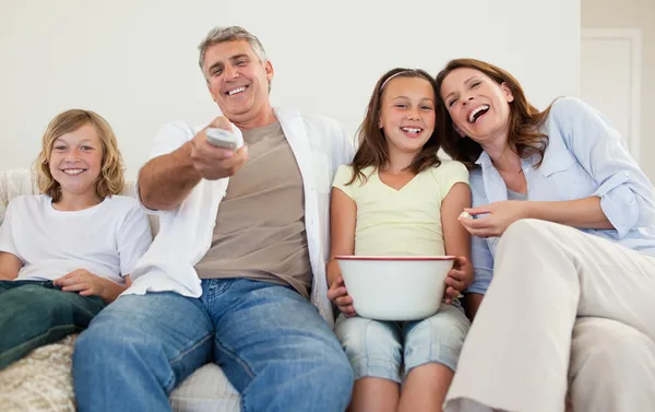 Familjen i soffan tittar på tv — Stockfoto