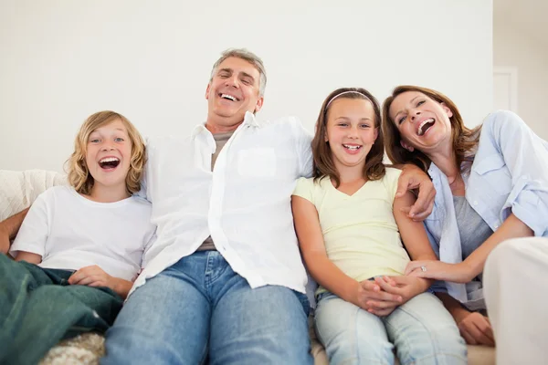 Aile kanepede oturan gülüyor — Stok fotoğraf