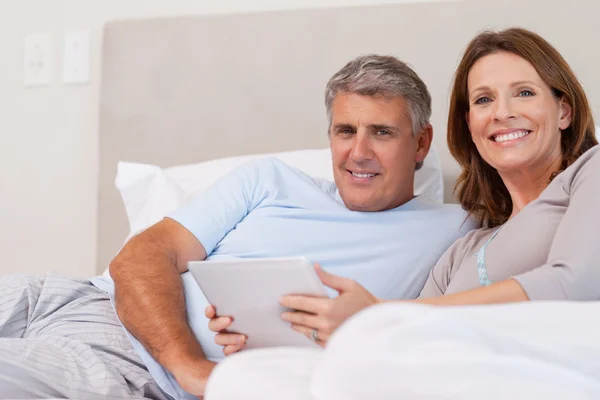 Paar mit Tablette im Bett — Stockfoto