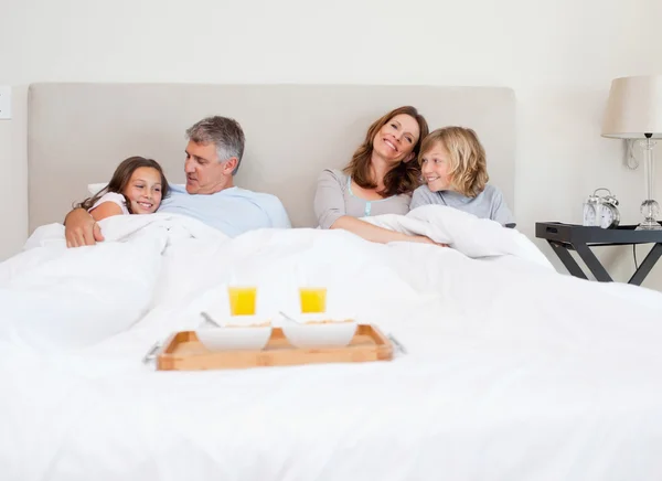 Família prestes a tomar café da manhã na cama — Fotografia de Stock
