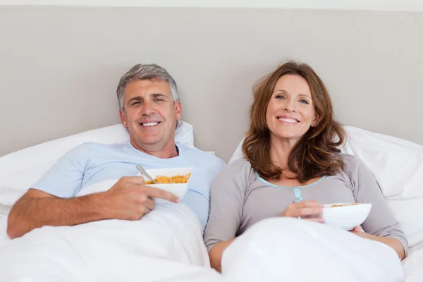 Ζευγάρι τρώει δημητριακά στο κρεβάτι — Φωτογραφία Αρχείου