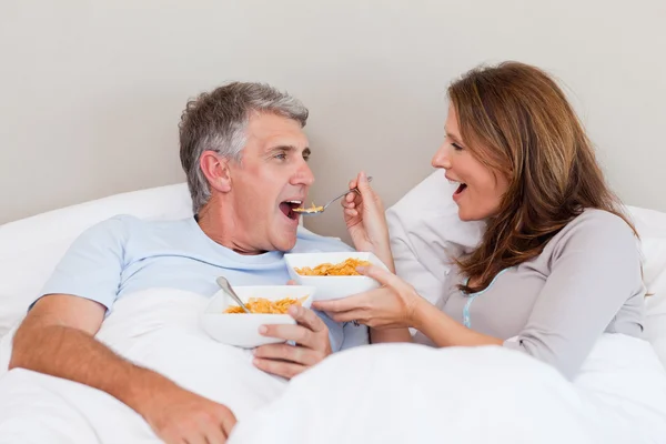 Ώριμο ζευγάρι τρώει δημητριακά στο κρεβάτι — Φωτογραφία Αρχείου