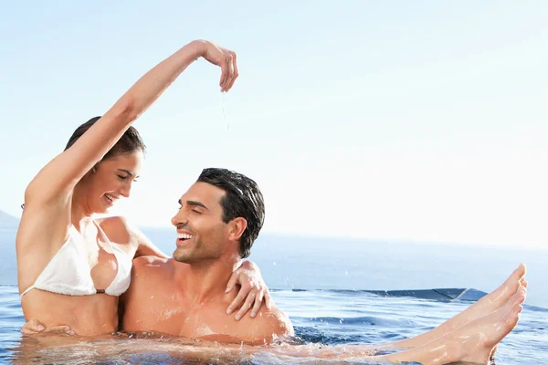 Ευτυχισμένο ζευγάρι που απολαμβάνετε το χρόνο μαζί στην πισίνα — Φωτογραφία Αρχείου