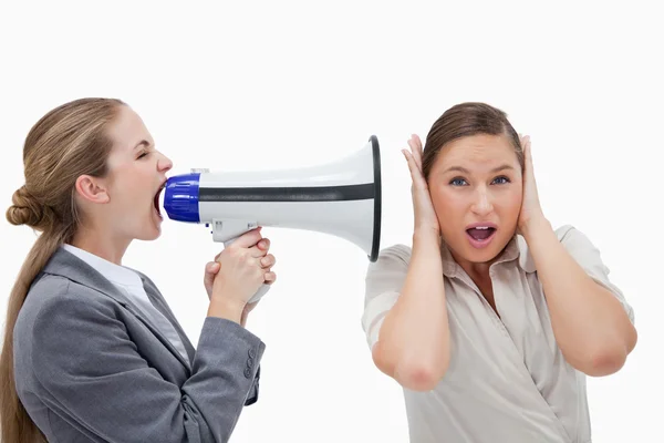 Businesswoman yelling at her coworker through a megaphone — Stock Photo, Image