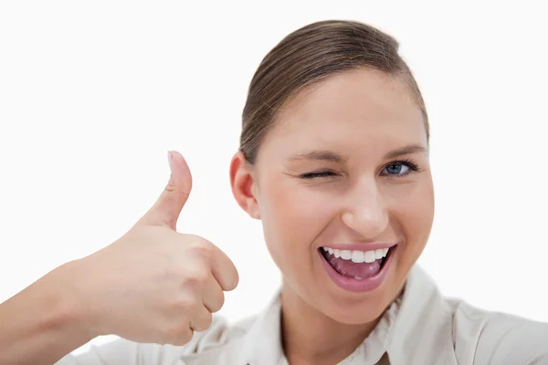 Businesswoman with the thumb up while winking — Stock Photo, Image
