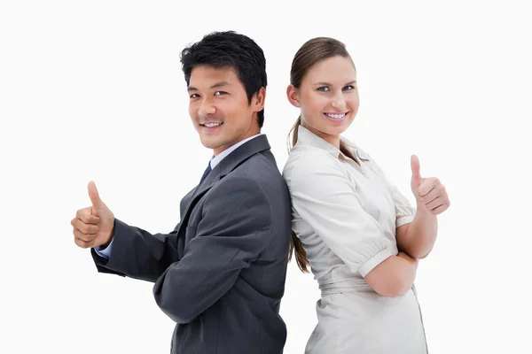 Business standing back to back with the thumb up — Stock Photo, Image