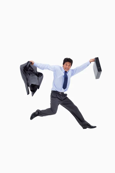 Empresário alegre pulando enquanto segurava seu casaco e uma brie — Fotografia de Stock