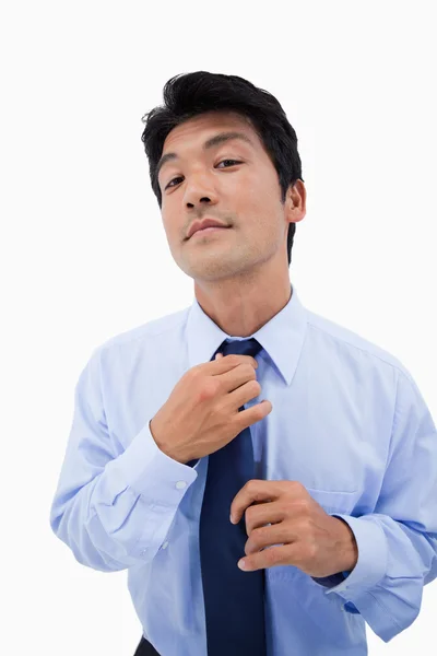 Retrato de um empresário relaxado consertando sua gravata — Fotografia de Stock