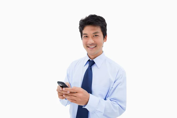 Empresário sorridente enviando uma mensagem de texto — Fotografia de Stock