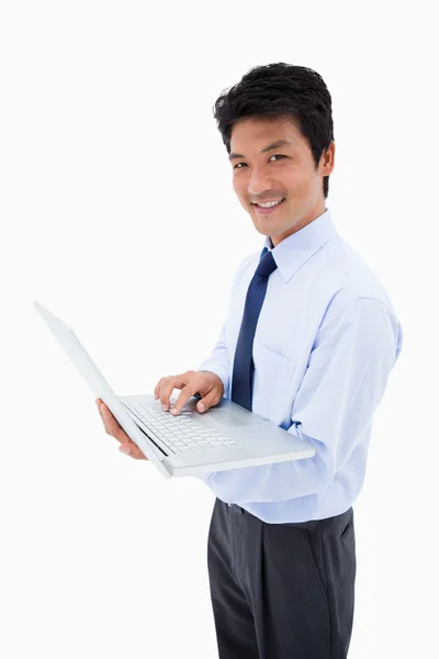 Bir dizüstü bilgisayar kullanarak bir gülümseyen işadamı portresi — Stok fotoğraf