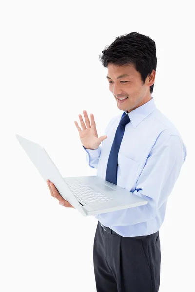 Portrait of a businessman waving at a laptop — Stock Photo, Image