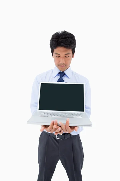 Porträtt av en affärsman som visar en laptop — Stockfoto