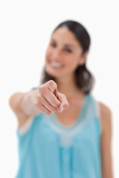 Portrait of a smiling woman pointing at the viewer — Stock Photo, Image