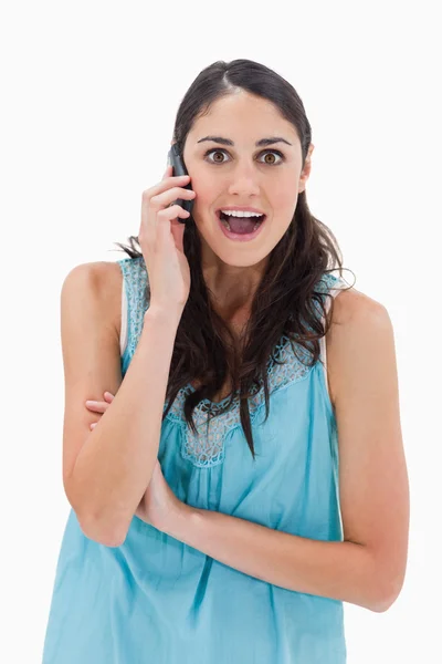 Porträtt av en förvånad kvinna att göra ett telefonsamtal — Stockfoto