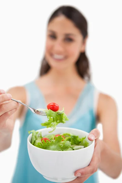 Retrato de uma mulher mostrando uma salada — Fotografia de Stock
