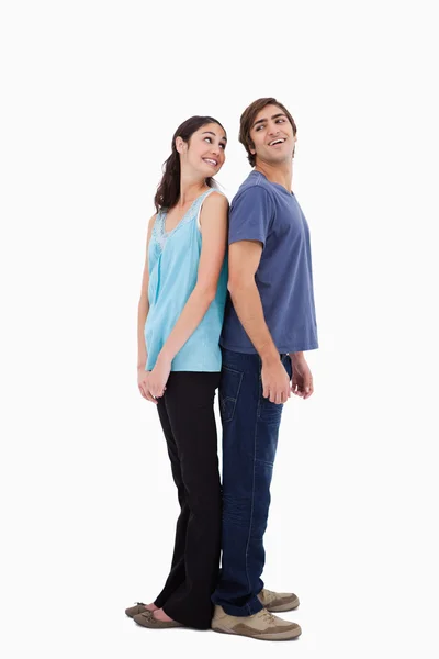 Портрет улыбающейся пары, стоящей спиной к спине — стоковое фото