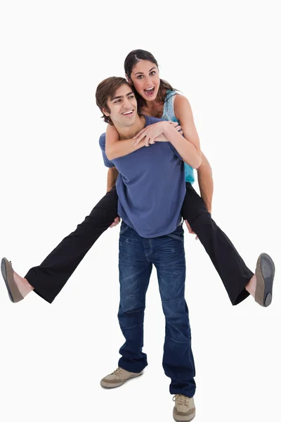 Portrait of man holding his girlfriend on his back — Stock Photo, Image