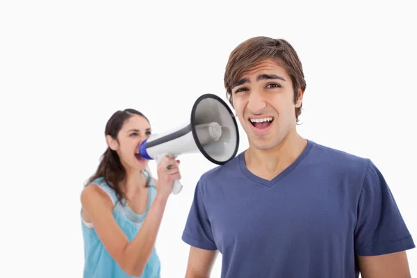 Woman yelling at her boyfriend through a megaphone — Stock Photo, Image