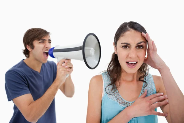 Uomo gridando alla sua ragazza attraverso un megafono — Foto Stock