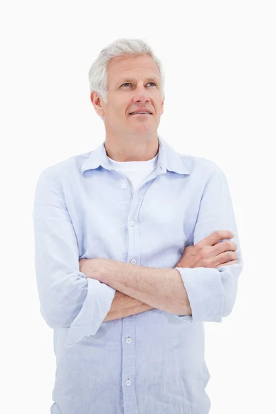 Портрет взрослого мужчины со скрещенными руками, смотрящего вверх — стоковое фото
