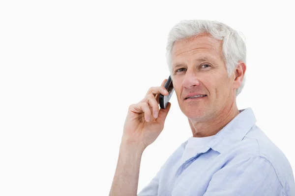 Side view of a man making a phone call while looking at the came — Stock Photo, Image