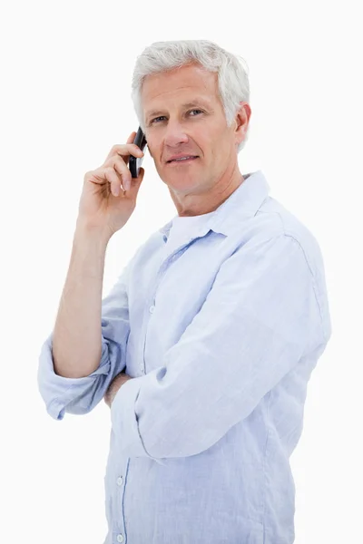 Retrato de um homem que faz um telefonema enquanto olha para a câmara — Fotografia de Stock