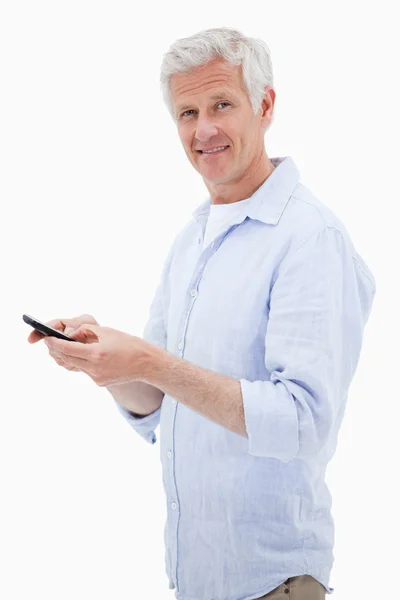 Porträtt av en man som använder sin mobiltelefon medan du tittar på ca — Stockfoto