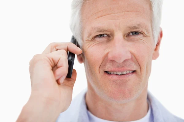 Улыбающийся взрослый мужчина делает телефонный звонок — стоковое фото