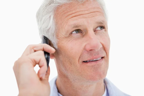 Mature man making a phone call while looking up — Stock Photo, Image