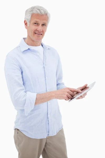 Πορτρέτο του ένα χαμογελαστό ώριμος άνδρας, χρησιμοποιώντας έναν υπολογιστή δισκίο — Φωτογραφία Αρχείου