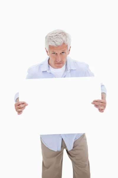 Retrato de un hombre maduro sosteniendo un tablero en blanco — Foto de Stock