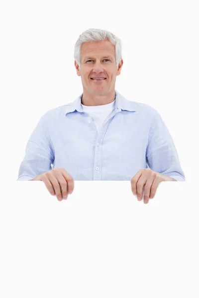 Retrato de um homem maduro em pé atrás do tabuleiro em branco — Fotografia de Stock