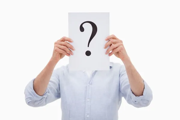 Portrait of a man hiding his face behind a question mark — Stock Photo, Image