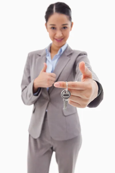 Portrét podnikatelka drží klíč s palcem — Stock fotografie