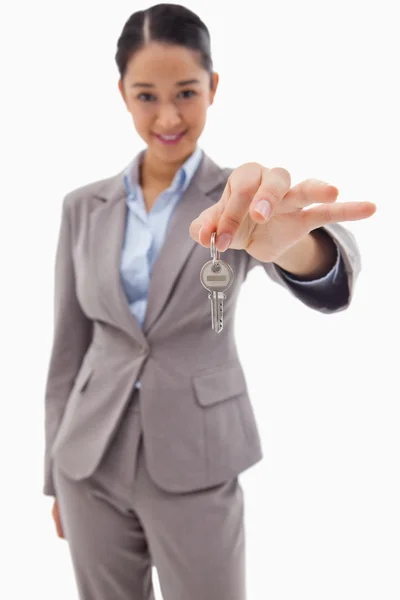 Portrait of a smiling businesswoman holding a key — Stock Photo, Image