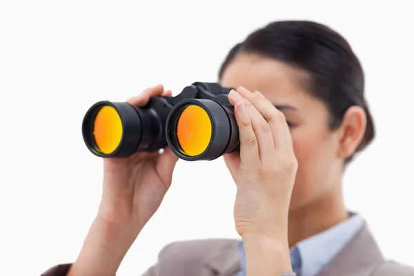 Brunette businesswoman looking through binoculars — Stock Photo, Image
