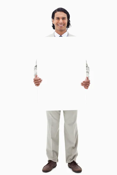 Empresario sosteniendo cartel en blanco — Foto de Stock