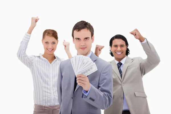 Empresário com colegas torcendo e dinheiro — Fotografia de Stock