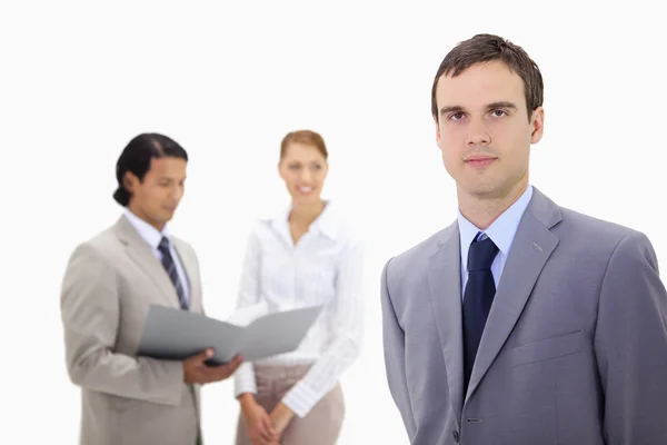 Young businessman with colleagues behind him — Stock Photo, Image