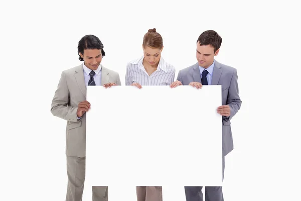 Businessteam looking at blank sign in their hands — Stock Photo, Image