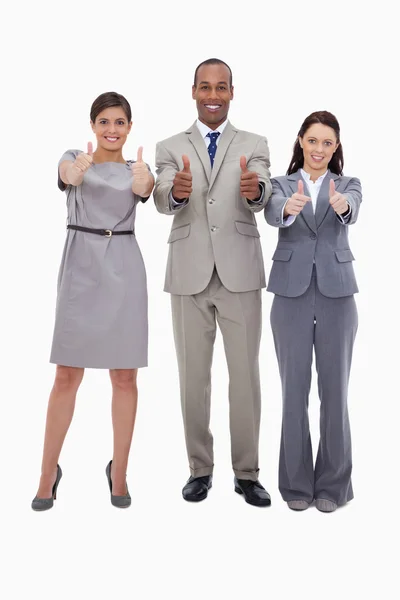 Smiling businessteam giving thumbs up — Stock Photo, Image