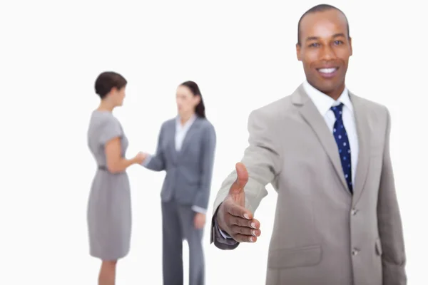 Smiling businessman offering his hand with hand shaking colleagu — Stock Photo, Image
