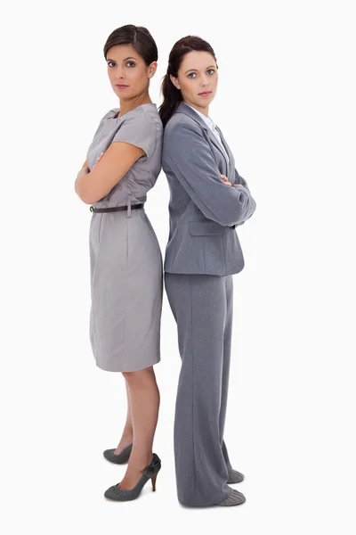 Serious businesswomen standing back on back — Stock Photo, Image