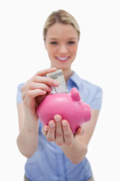 Dinheiro sendo colocado no banco porquinho por mulher — Fotografia de Stock