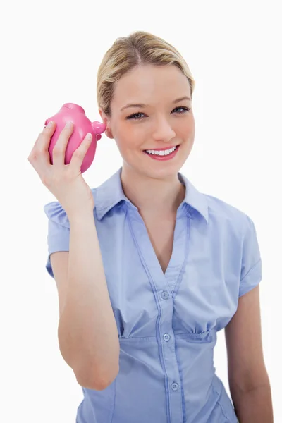 Smiling woman shaking her piggy bank — Stock Photo, Image
