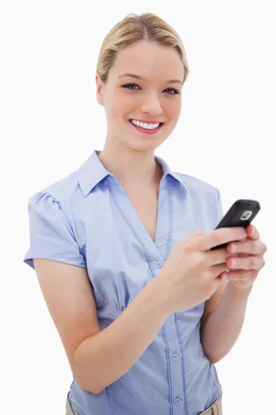 Mujer sonriente sosteniendo su teléfono celular — Foto de Stock