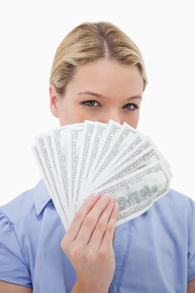 Mulher escondendo seu rosto atrás do dinheiro — Fotografia de Stock