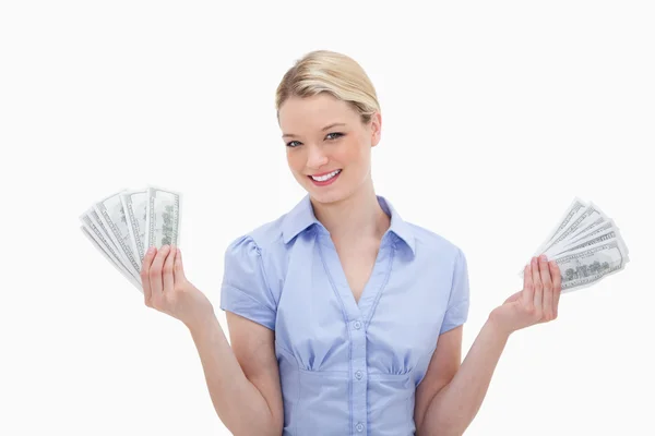 微笑的女人，在她手中持有的钱 — 图库照片