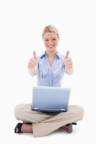 Kobieta siedzi z laptopa daje kciuk w — Zdjęcie stockowe